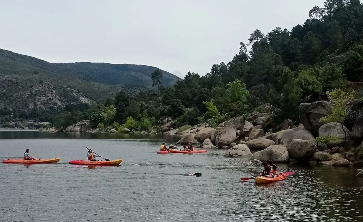 Kayaks remando junto a la orilla rocosa del embalse de El Burguillo
